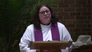 Angela LaMoore preaches in front of palms in the Nativity sanctuary