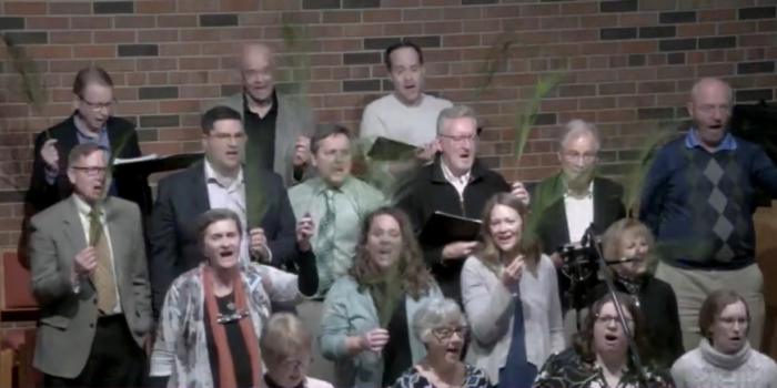 Nativity Choir singing with brick wall in background