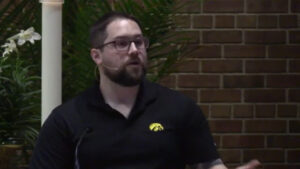 Deacon Kyle Soderberg preaching at Nativity Lutheran Church in sanctuary with brick background
