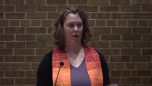 Hannah Campbell Gustafson preaching at Nativity Lutheran Church with brick background