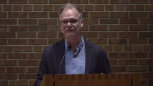 Dan Bielenberg speaking at Nativity Lutheran sanctuary with brick background