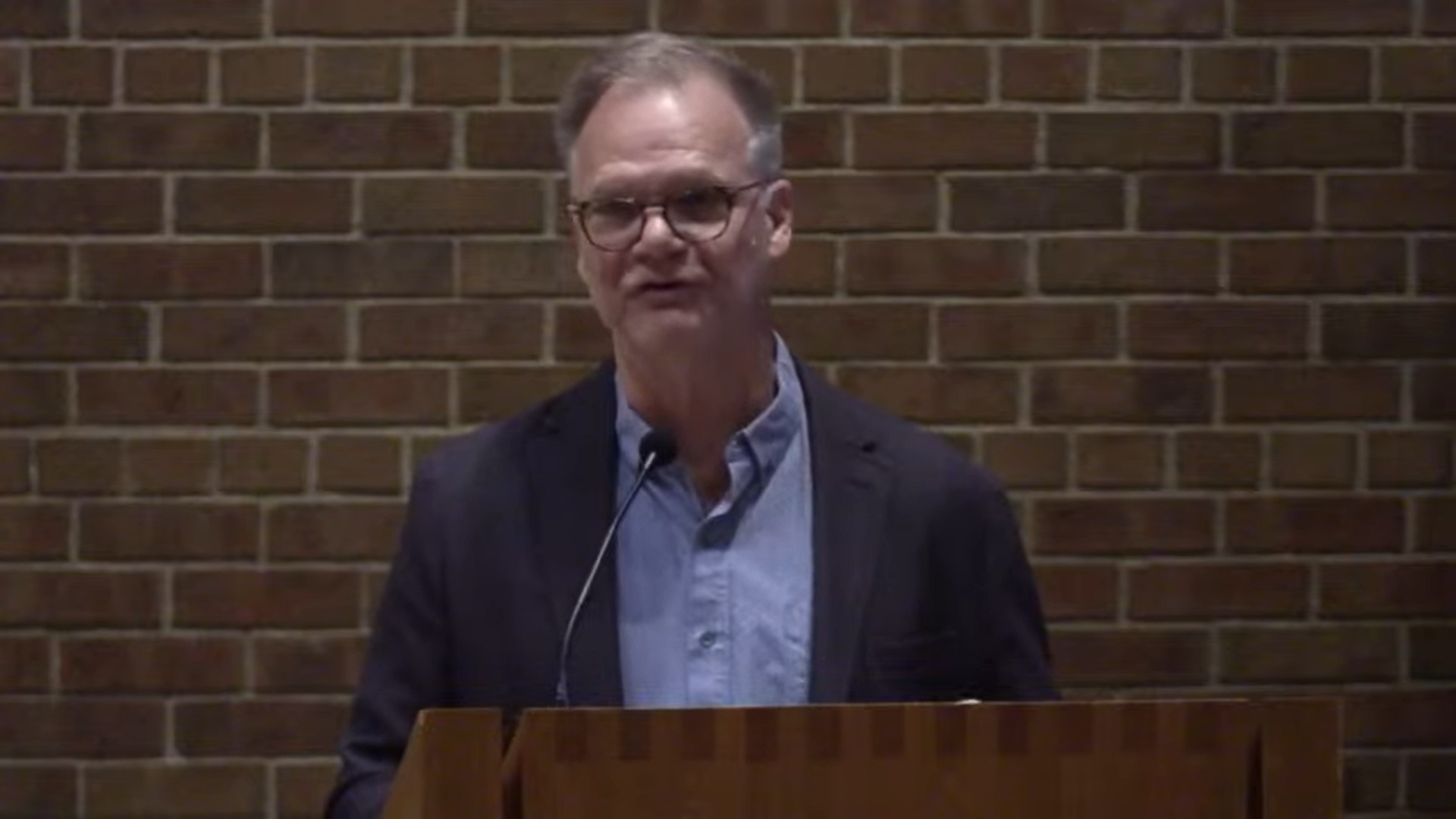 Dan Bielenberg speaking at Nativity Lutheran sanctuary with brick background