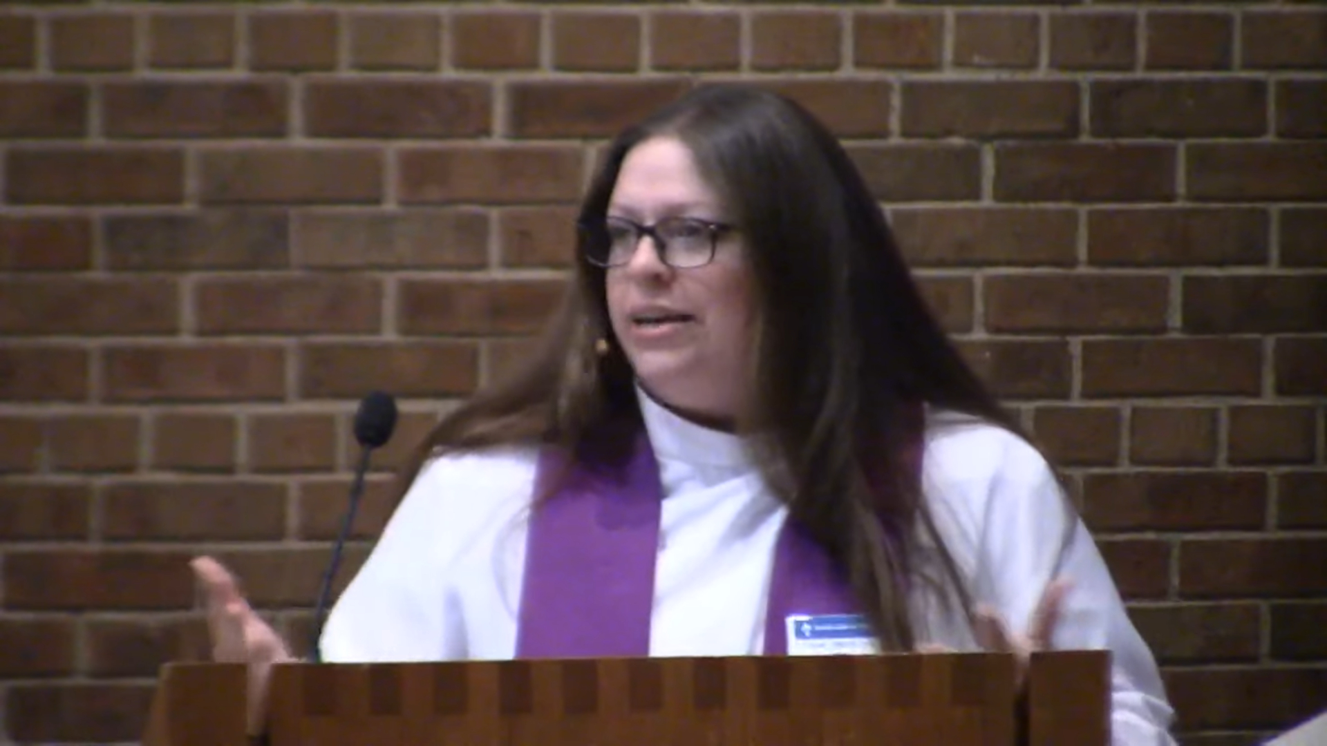 Pastor Angela LaMoore preaching against brick background